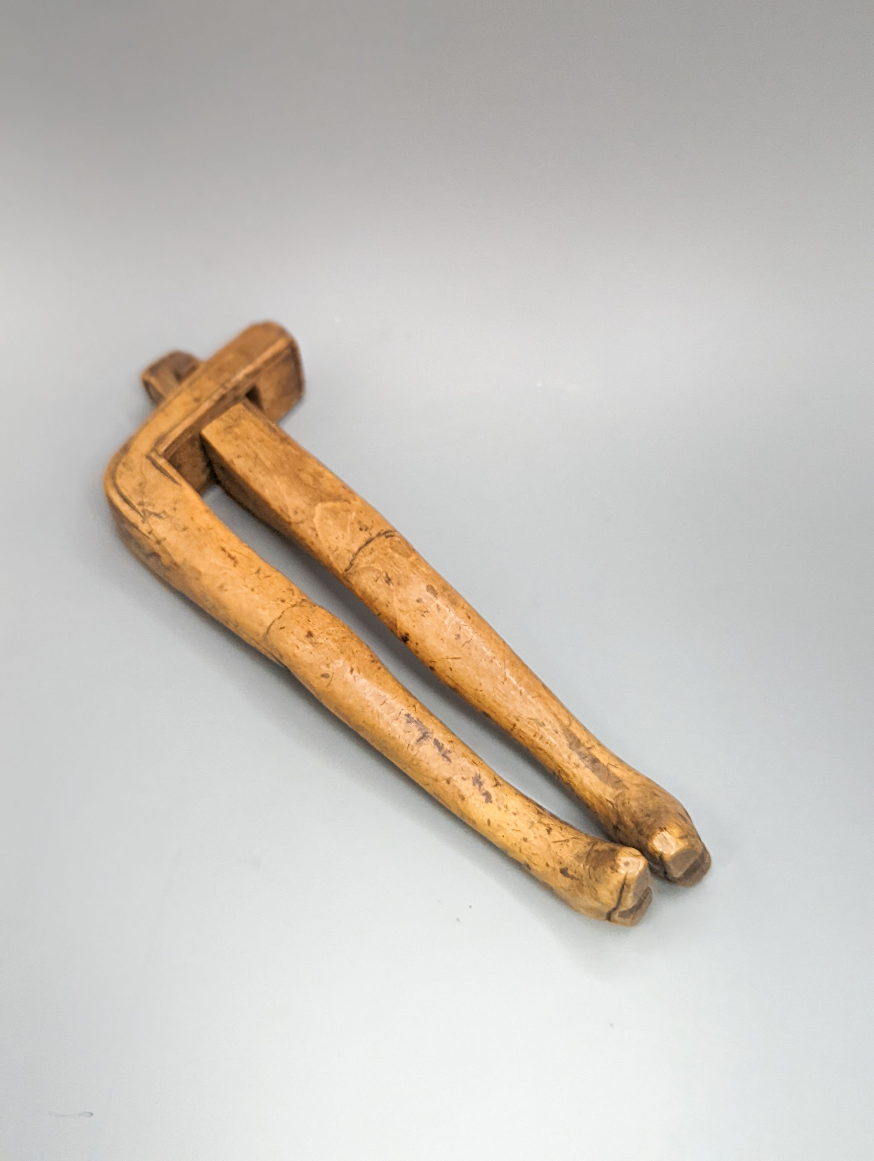 A pair of Georgian treen ‘riding boot’ nutcrackers, 14.5cm and two 19th century acorn-shaped Treen nutcrackers (3)
